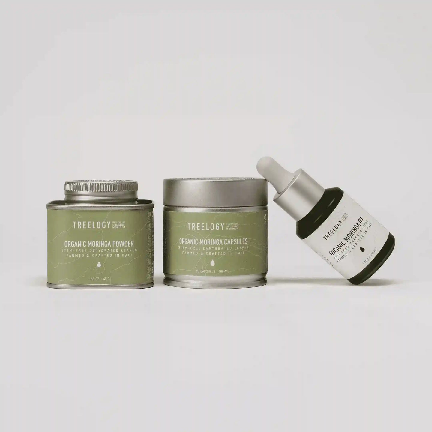 Treeology skincare products including a tin, jar, and dropper bottle on a light gray background