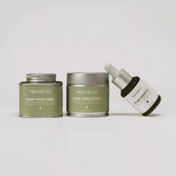 Treeology skincare products including a tin, jar, and dropper bottle on a light gray background