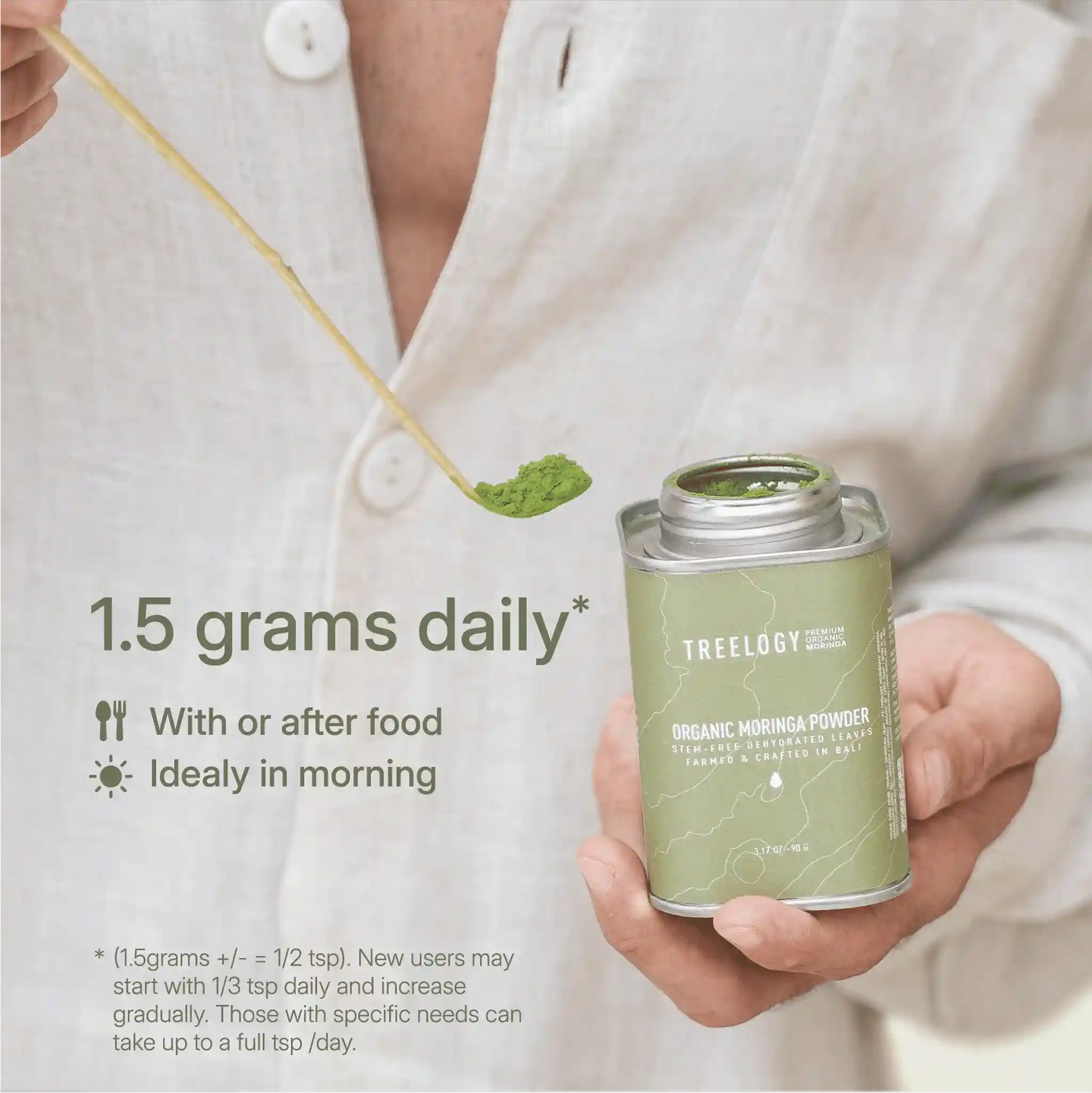 Moringa powder being scooped from a tin, with a guide recommending 0.5 tsp daily, preferably in the morning with meals.
