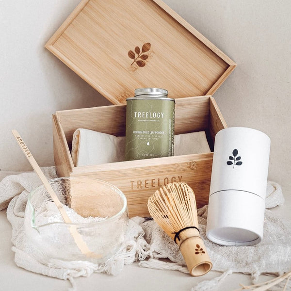 The complete Treelogy Moringa Ritual Set arranged in a flatlay, including oil, capsules, mixing tools, and packaging for a full natural wellness experience.