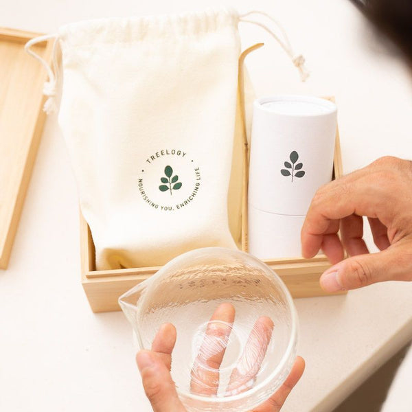Flatlay of the Treelogy Ritual Starter Set including a cotton pouch, eco-friendly packaging, and a glass bowl arranged neatly in a wooden box.
