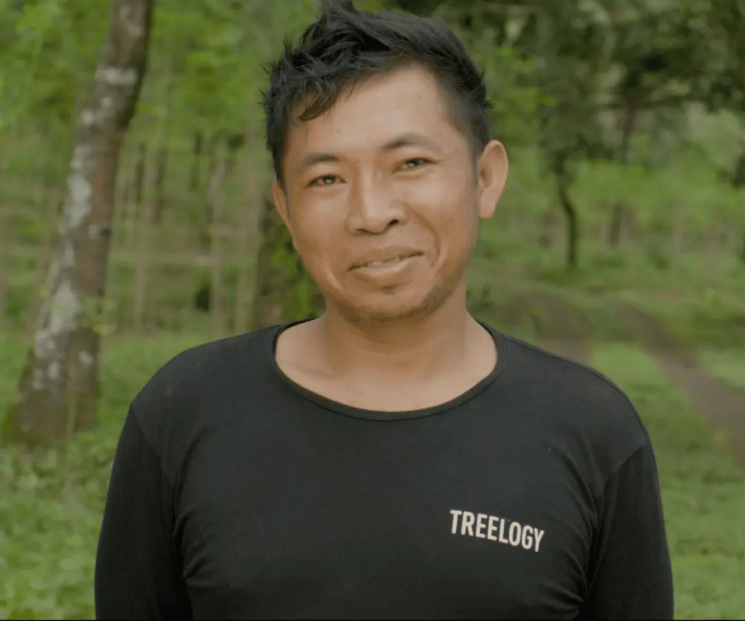 I Gede Sukra standing outdoors with greenery and trees in the background.