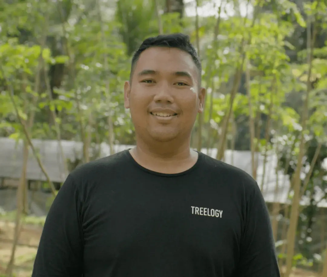 Setiadi Jitendhriyawan Suwarno smiling while standing outdoors with greenery in the background.