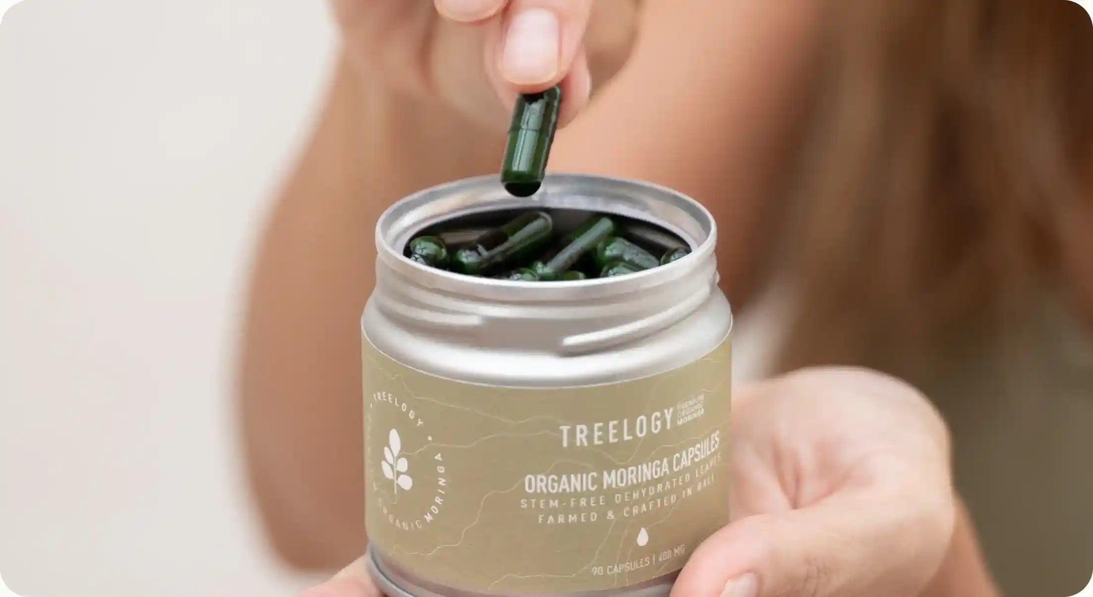 Opening a tin of moringa capsules